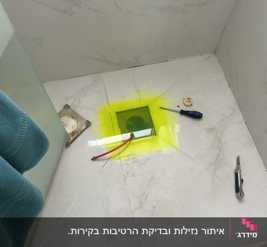 כלים על רצפת חדר אמבטיה עם סימון צהוב